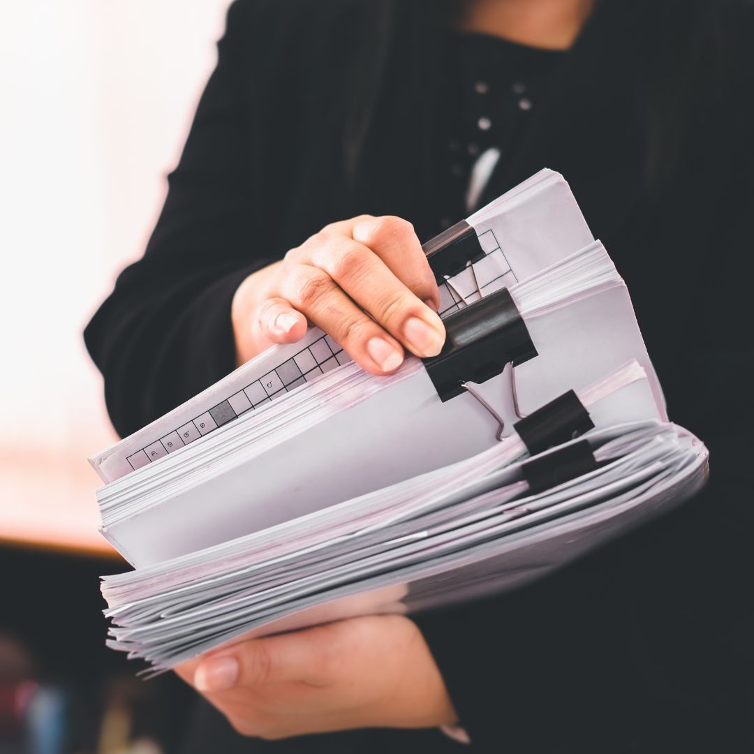 business person holding a stack of documents